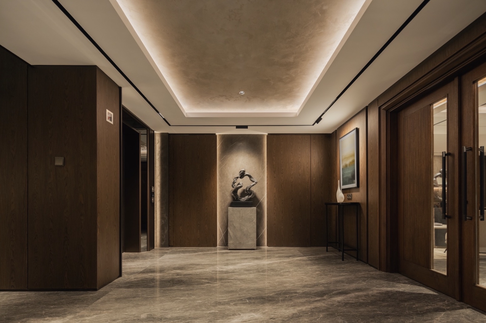 Warmly lit corridor with cove lighting and sculpture